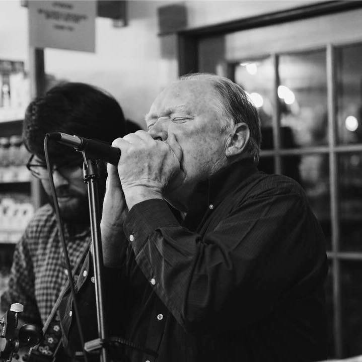 black and white photo of a man singing into a microphone