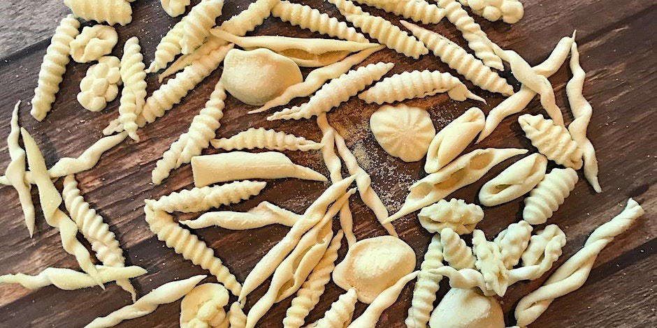 various pasta dough shapes on a wooden work surface