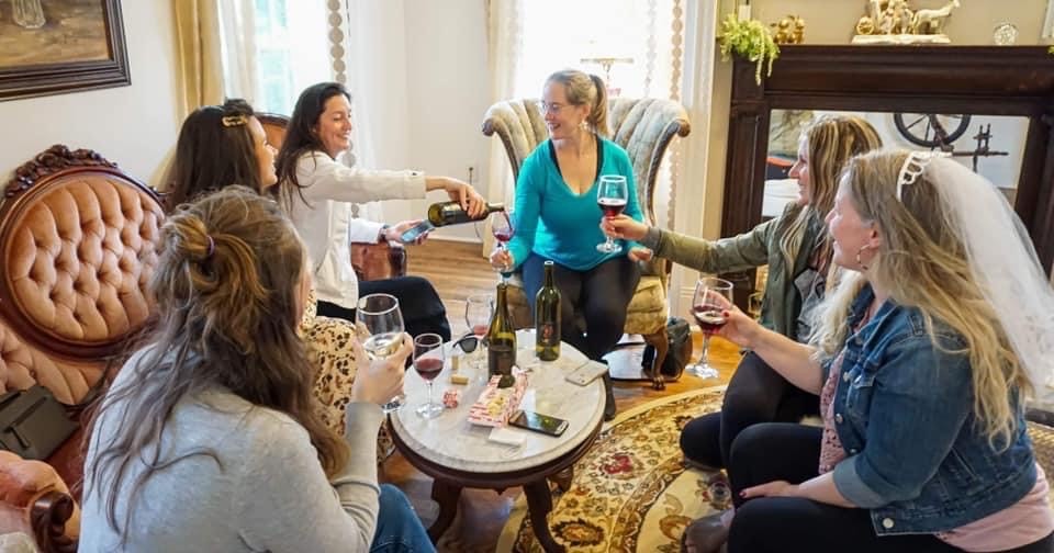Picture of people sitting around a table with wine.